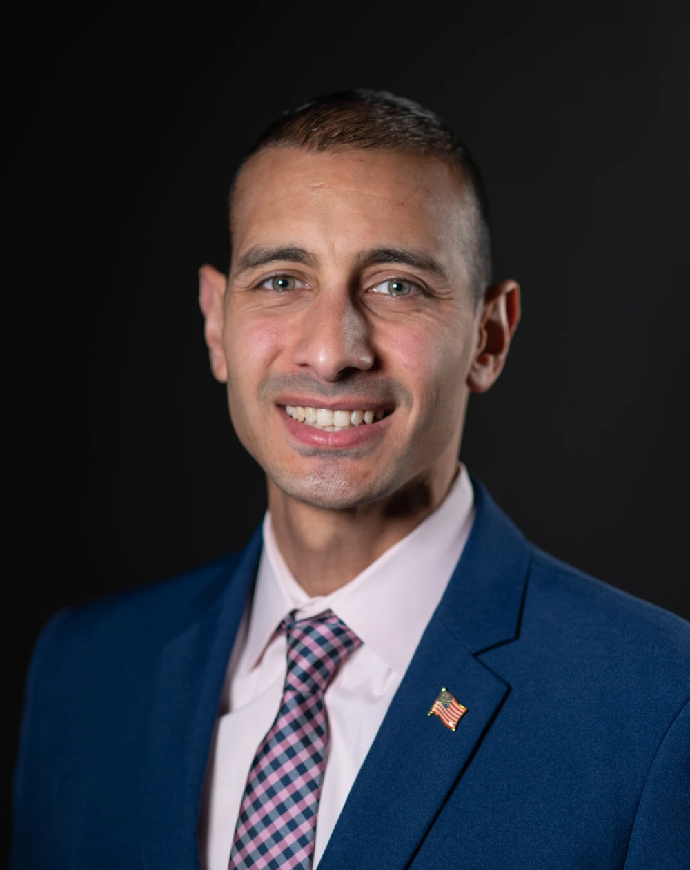 Abdel Elnoubi in a suit with an american flag pin on his lapel